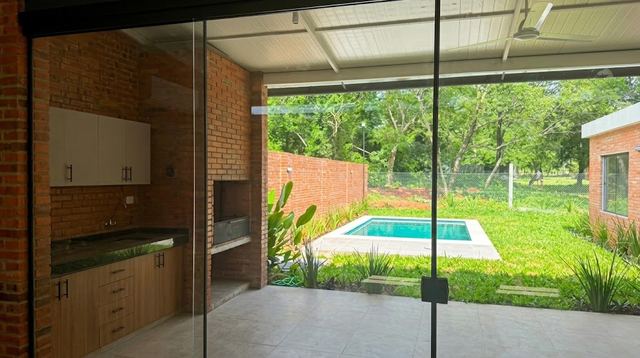 Überdachte Galerie mit Grill und Blick auf Pool und Garten
